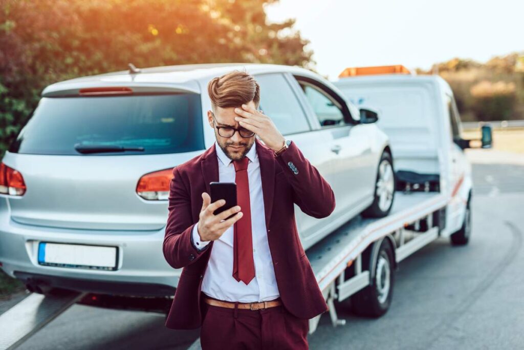 Drivers stand safely beside two damaged cars while documenting the crash scene with a phone.